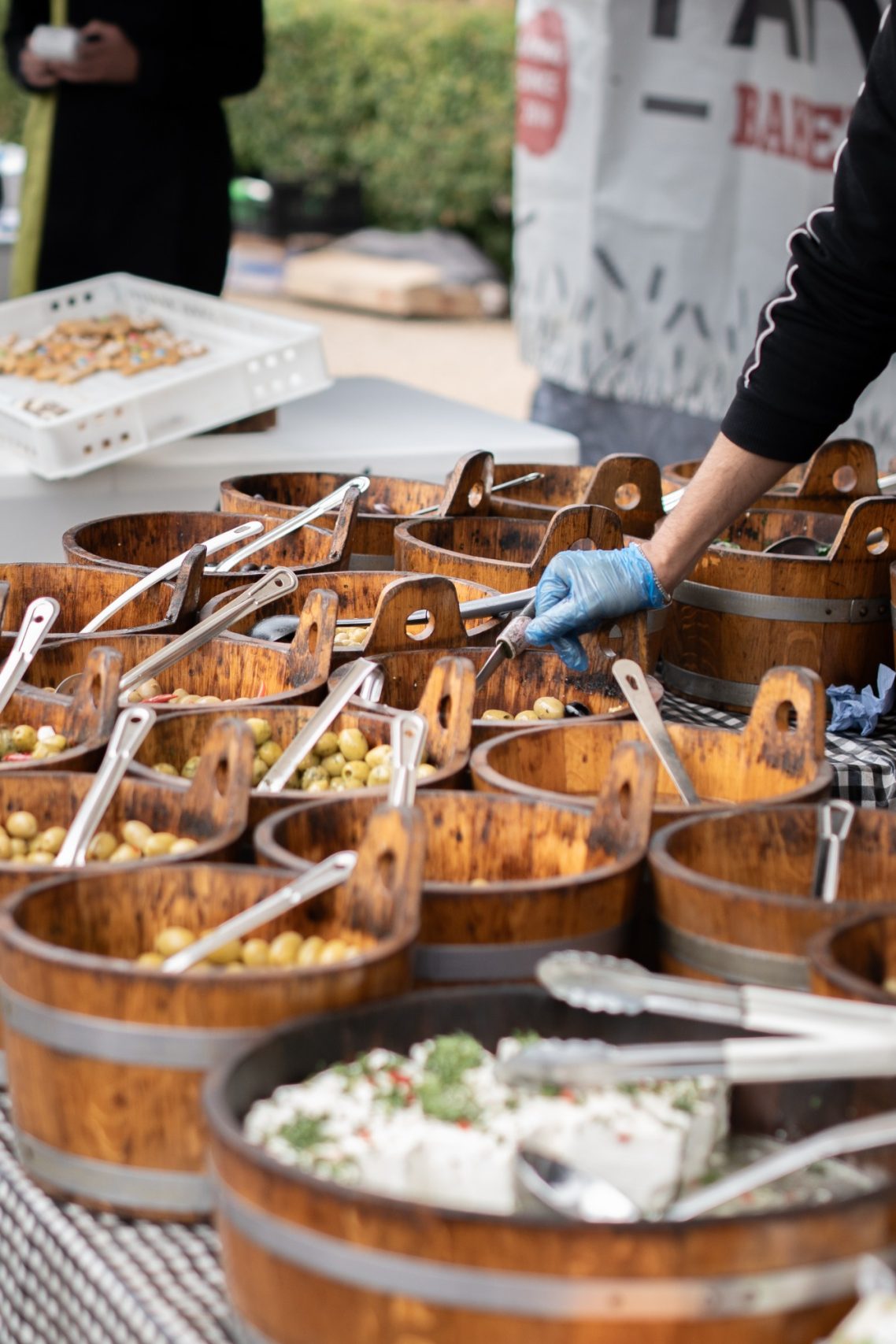 A selection of wooden bowls filled with various colourful food items and serving utensils.
